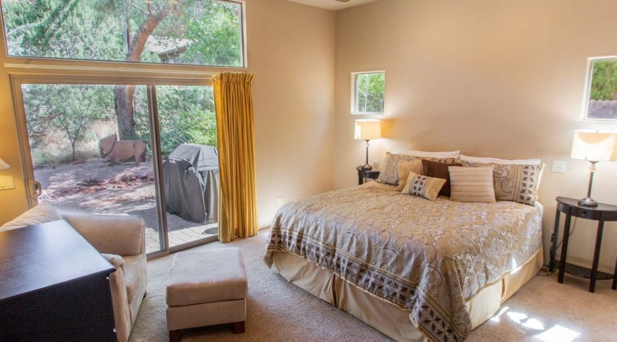 Master Bedroom—California King-sized pillow-top bed, sitting area, dresser, night tables, reading lamps, alarm clock. Sliding glass door leads to patio and affords view of Red Rock formations.