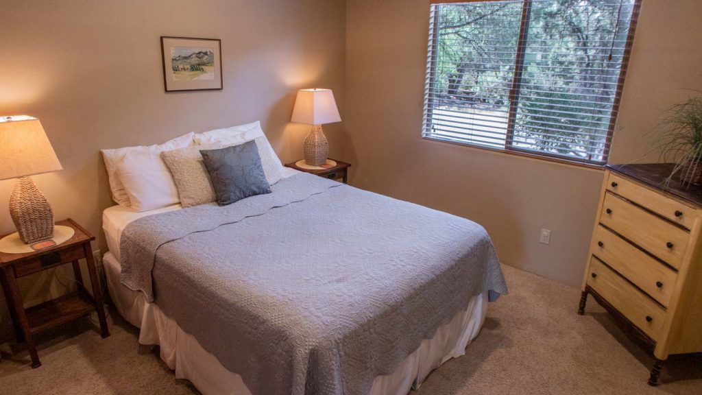 Bedroom Two—Queen-sized pillow-top bed, nightstands, dresser, reading lamp, ample closet space