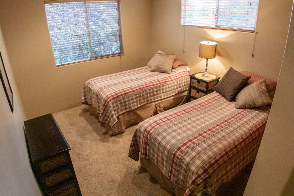 Bedroom Three—Two twin-sized pillow-top beds, nightstand, reading lamp, dresser, ample closet space.